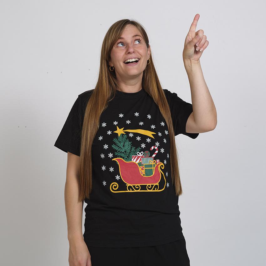 Eine Frau trägt ein schwarzes Weihnachts-T-Shirt mit dem Schlitten des Weihnachtsmanns.